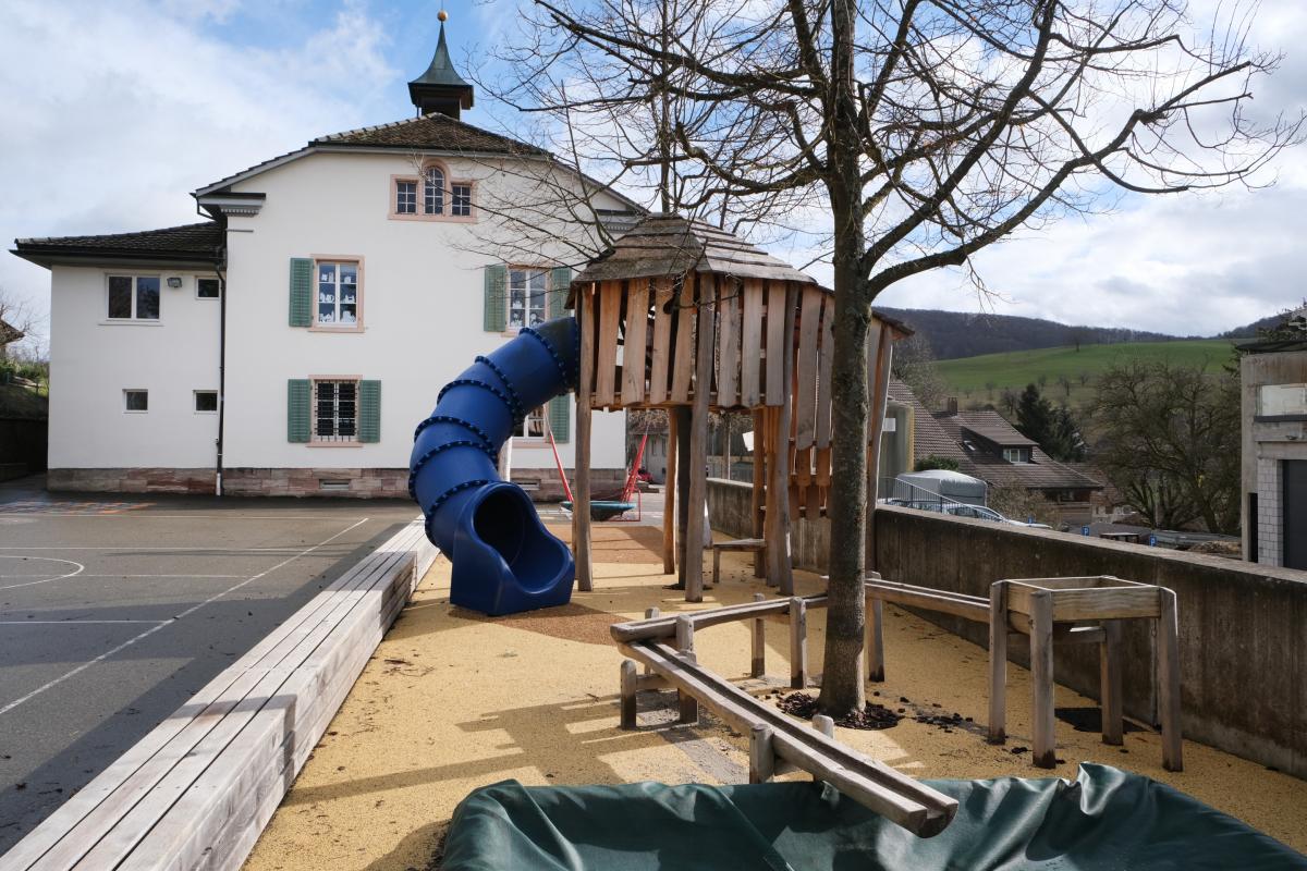 Schulhaus mit Spielplatz